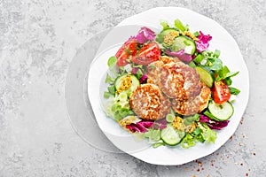 Cutlets and fresh vegetable salad on white plate. Fried meatballs with vegetable salad