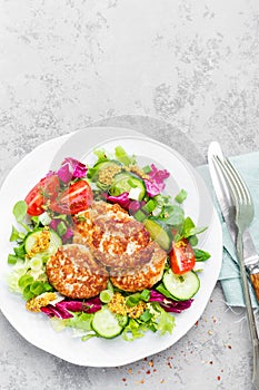 Cutlets and fresh vegetable salad on white plate. Fried meatballs with vegetable salad