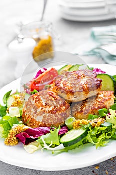 Cutlets and fresh vegetable salad on white plate. Fried meatballs with vegetable salad