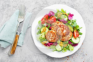 Cutlets and fresh vegetable salad on white plate. Fried meatballs with vegetable salad