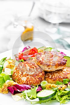 Cutlets and fresh vegetable salad on white plate. Fried meatballs with vegetable salad