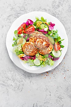 Cutlets and fresh vegetable salad on white plate. Fried meatballs with vegetable salad