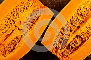 Cutted fresh orange big pumpkin on wooden background, close up. Organic agricultural product, ingredients for cooking