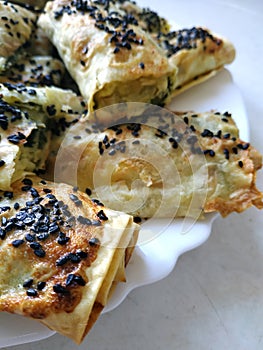 Cutted lavash pieces with vegetables. Burek with spinach and cheese and black cumin. Yufka