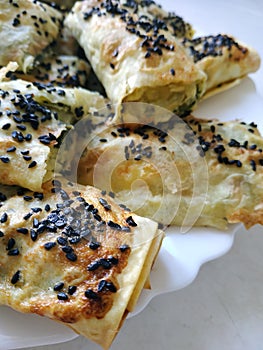 Cutted lavash pieces with vegetables. Burek with spinach and cheese and black cumin. Yufka