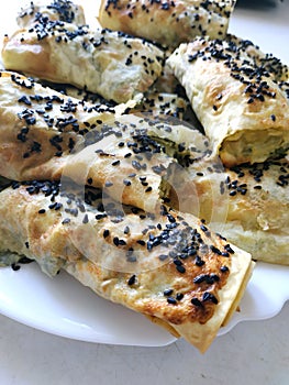 Cutted lavash pieces with vegetables. Burek with spinach and cheese and black cumin. Yufka