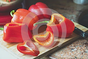 Cutted red bell peppers ready for preparing on a wooden board