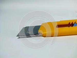 Cutter blade with yellow handle isolated on white background. Sharper object to cut paper