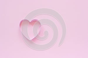 Cutter cookies in heart shape on pastel pink background. Concept Valentine`s card. Top view Copy space for text