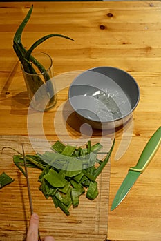 Cutting Aloe Vera on a wooden plate with gel in Grey bowl