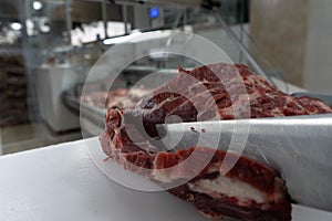 Cutting of Argentine meat in butchery with knife photo