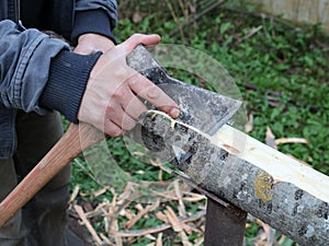 Cutting bark from a log with an ax