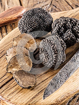 Cutting of black truffle on the wooden board