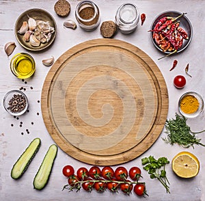 Cutting board, around lie ingredients for cooking vegetarian food, tomatoes on a branch, spices, cucumbers butter place for text,