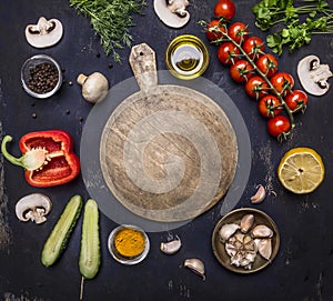 Cutting board, around lie ingredients variety of vegetables and fruits, place for text,frame wooden rustic background top view