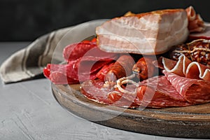 Cutting board with different meat delicacies on gray