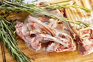 cutting board with fresh lamb ribs decorated with rosemary