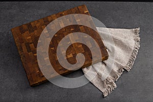 Cutting board on a grey stone table. Isolated on a black background. Culinary background. Empty wooden cutting board