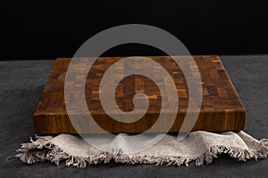 Cutting board on a grey stone table. Isolated on a black background. Culinary background. Empty wooden cutting board