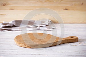 Cutting board and kitchen towel on a wooden background