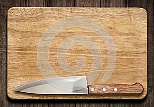 Cutting board and knife on old wood table