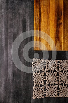 Cutting board with linen napkin on black wooden background