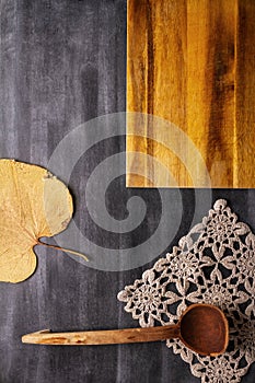 Cutting board with linen napkin and spoon on black wooden background