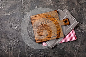 Cutting board over towel on wooden kitchen table.