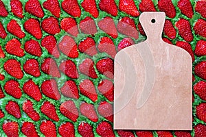 A cutting board with a place for text is placed on a strawberry