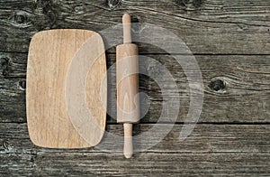 Cutting board with rollingpin on wooden background photo