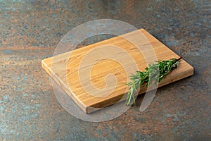 Cutting board and rosemary on an old wooden table