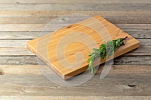 Cutting board and rosemary on an old wooden table