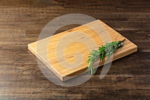 Cutting board and rosemary on an old wooden table