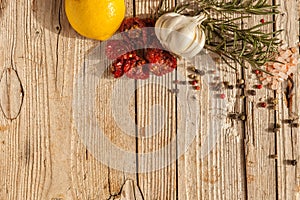 Cutting Board, rosemary, tomatos, garlic and spices on a old wooden table