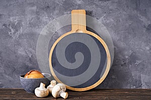 Cutting board and vegetables on a gray background, place for text