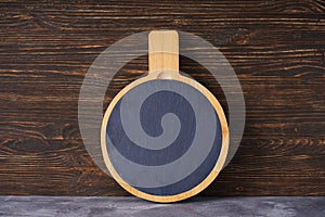 Cutting board on a wooden background, place for text