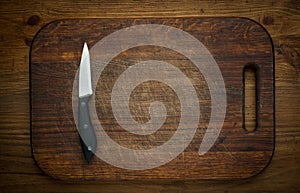 Cutting breadboard and knife overwooden background