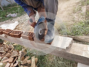 Cutting bricks with an angle grinder in a rural yard