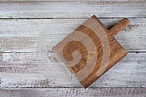Cutting brown board on old shabby wooden background. Background with copy space, overhead, top view