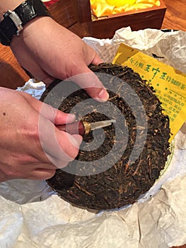 Cutting a Cake of Pu-erh Chinese tea