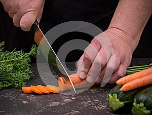 Cutting carrot on a stone table for meal preparation