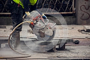 Cutting the curb with with cut-off saw. Road works