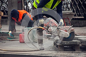 Cutting the curb with with cut-off saw. Road works