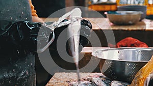 Cutting Fish in Market Stall. Woman Manual cleaning and Cuts Fresh Fish