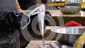 Cutting Fish in Market Stall. Woman Manual cleaning and Cuts Fresh Fish