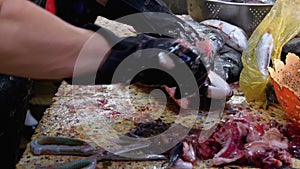 Cutting Fish in Market Stall. Woman Manual cleaning and Cuts Fresh Fish