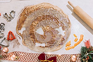 Cutting the gingerbread cookie dough to make tasty biscuits for Christmas and New Year`s Eve, closeup