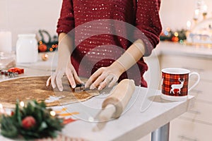 Cutting gingerbread dough with a Christmas tree -shaped metal cutter