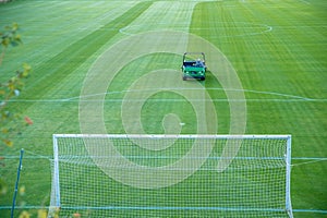 Cutting the grass before the game on the football field with a tractor