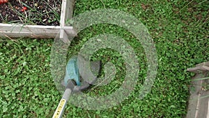 Cutting grass with string trimmer, close up point of view, nobody